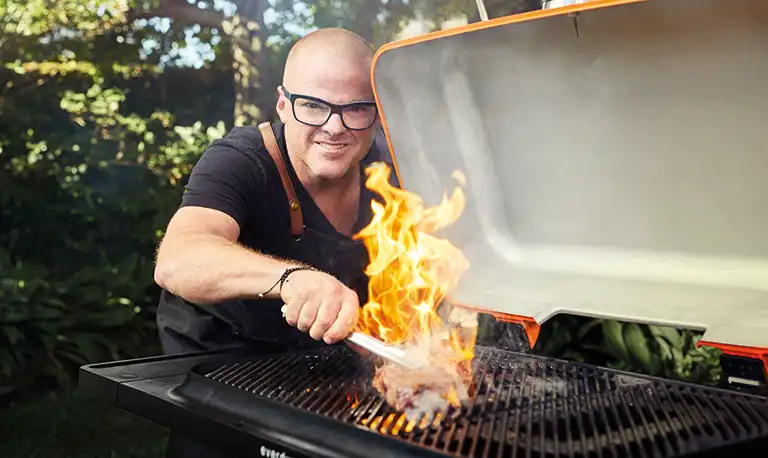 Heston cooking steak on a gas barbeque