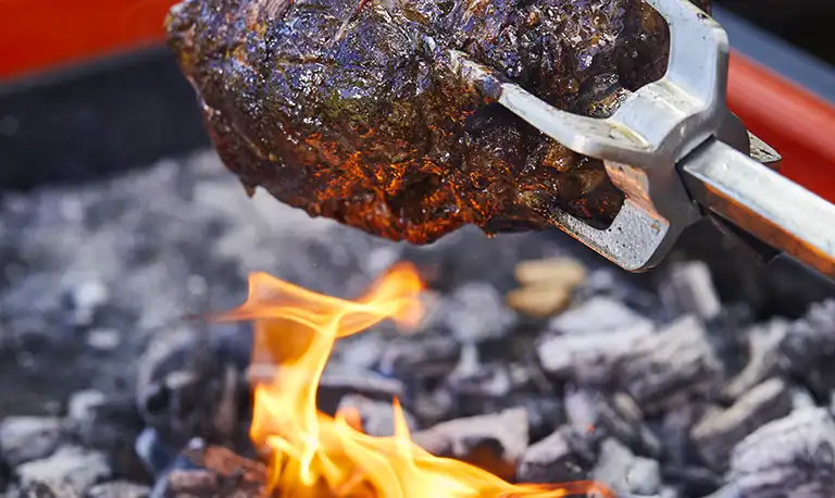 close up of lamb cooking on a charcoal barbeque